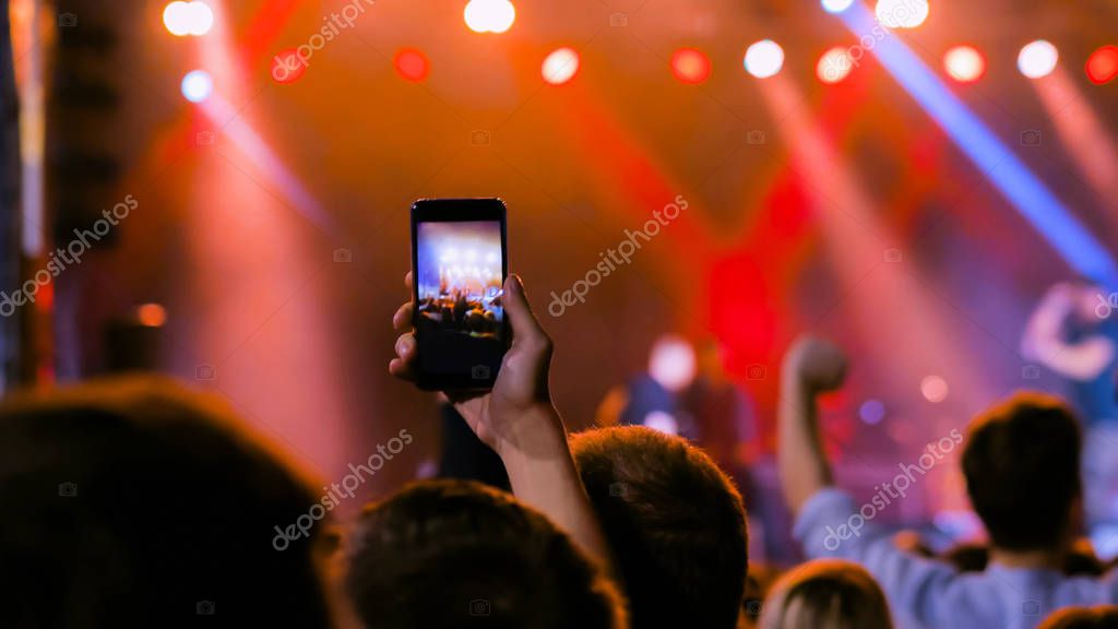 Pubblico che fotografa un concerto con il telefono